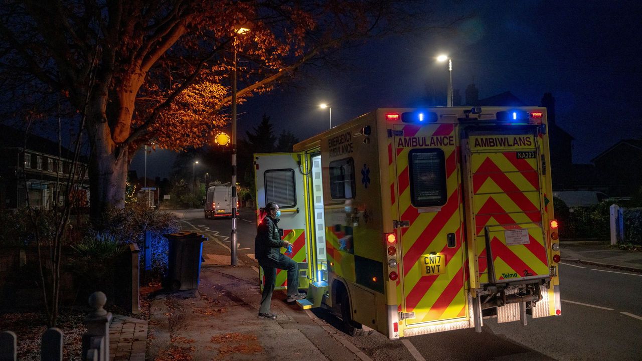 A paramedic enters an ambulance at a residential address.