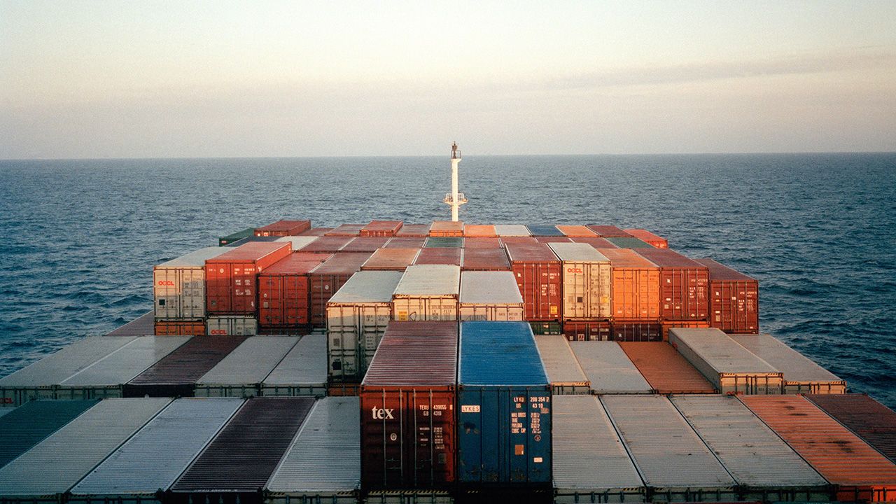 A cargo ship carries shipping containers via the sea.