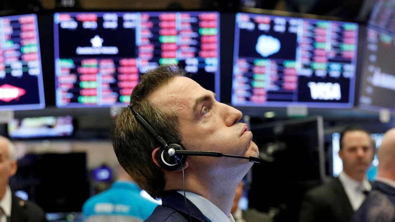 A trader looks up at a screen, on the floor of the New York Stock Exchange, shortly before the closing bell.