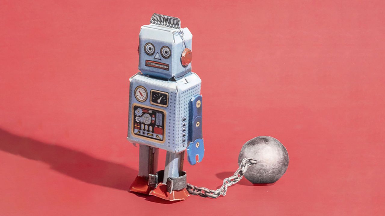 A windup toy robot with a ball and chain attached to its legs