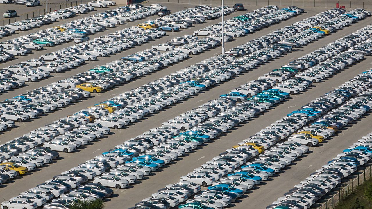 Aerial view of new electric cars parked at a manufacturing facility in China.