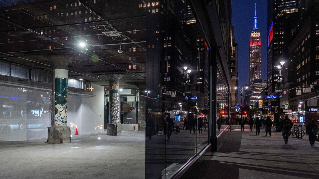 An empty groundfloor office space pictured next to a street, with the Empire State building on, in New York City.