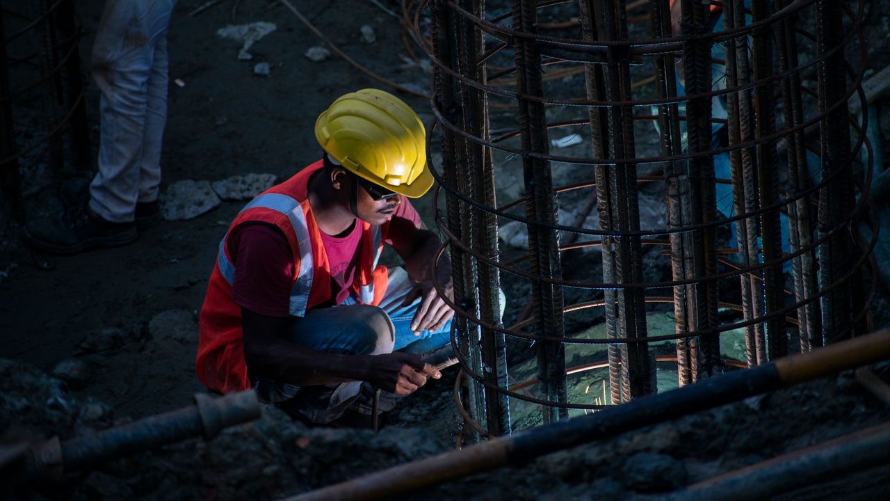 A construction worker building pillars for a bridge in India.