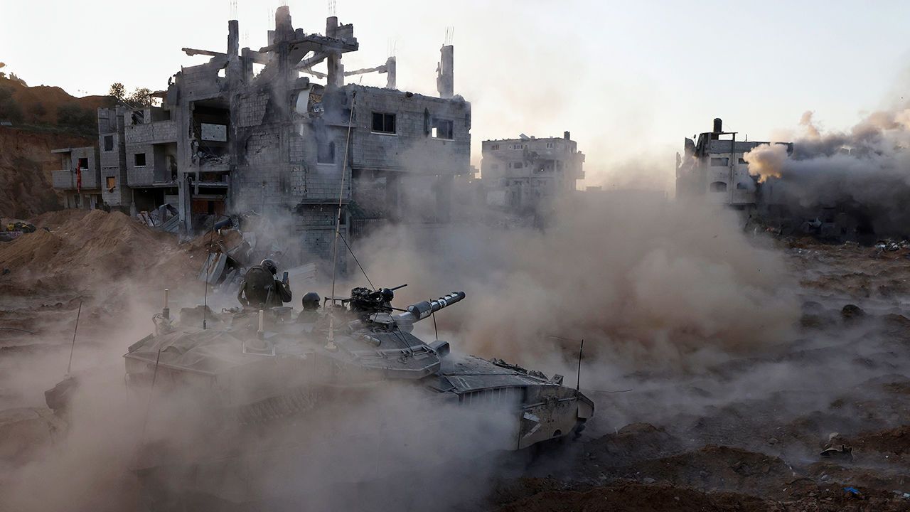 An Israeli tank drives through rubble in Gaza City.