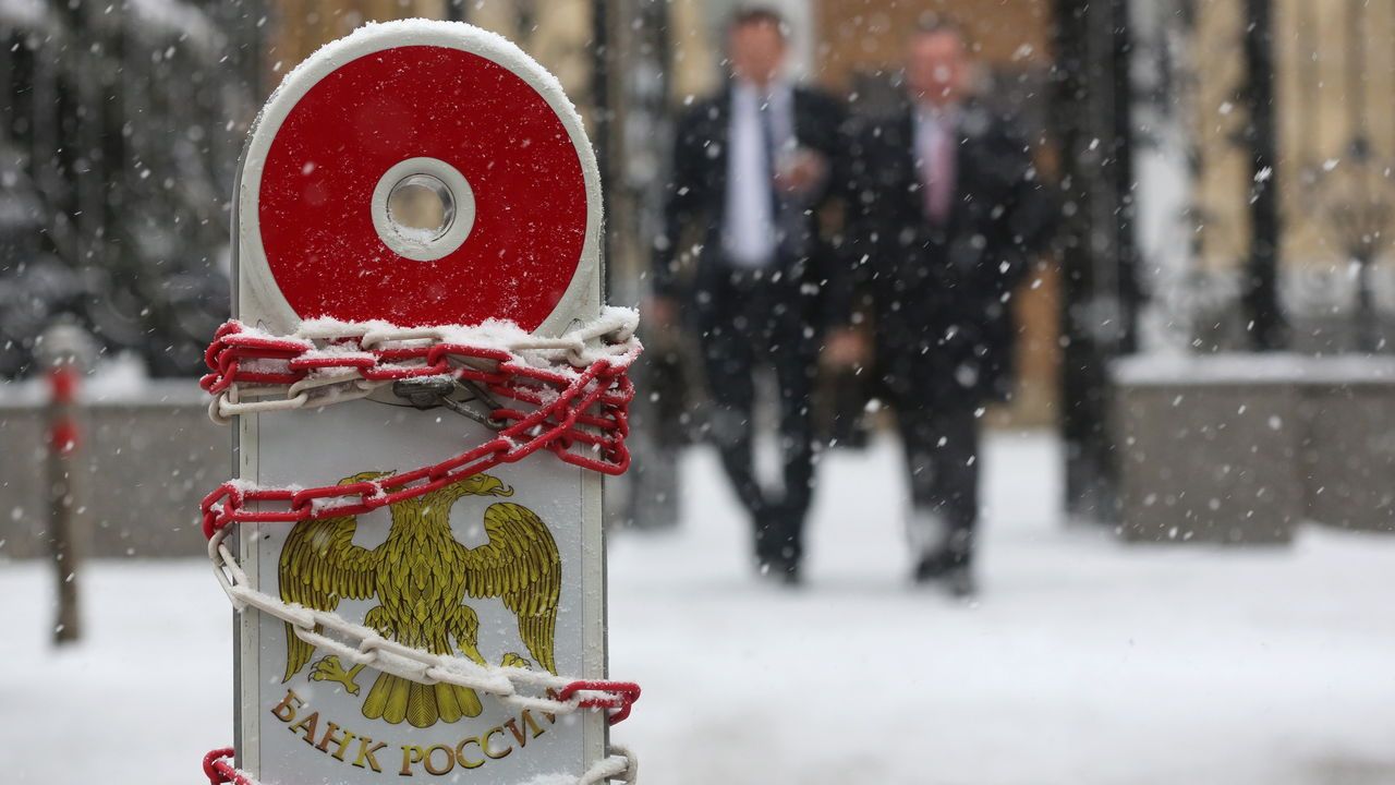 Visitors leave the headquarters of Russia’s Central Bank during a snow shower in Moscow