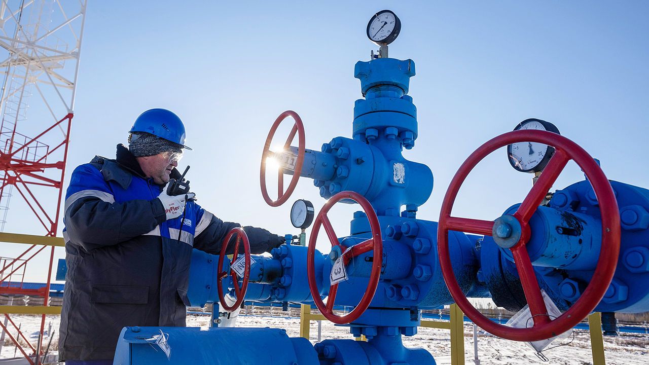 A worker turns a valve wheel at a gas well on a Gazprom base in Lensk district, Sakha Republic, Russia