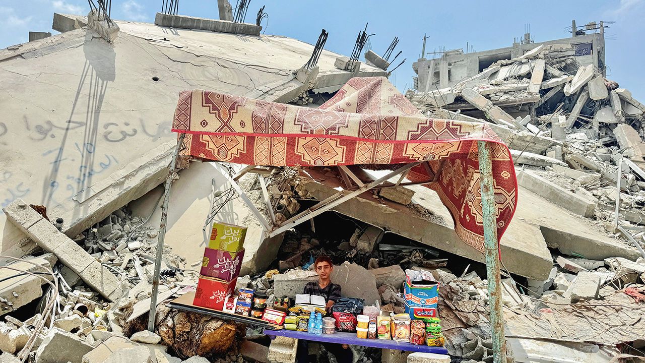 A Palestinian boy sits amidst the rubble of buildings destroyed after an Israeli strike in Khan Younis, Gaza