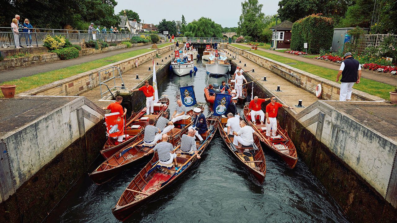 Crew members riding boats get ready to look for swans.